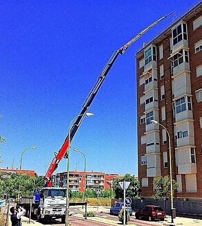 Camión Grúa PK 52500 Jib subiendo equipos de aire acondicionado a la cubierta de edificio